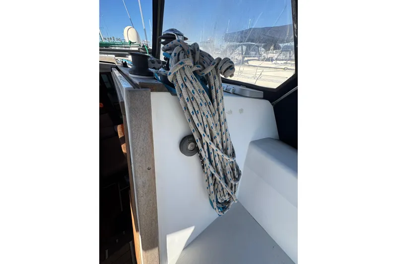 Coiled rope on 1989 Catalina 42 sailboat deck, with marina view.