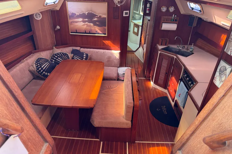Interior of a 1989 Catalina 42 sailboat with cozy seating and wooden finishes.