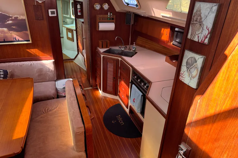 Interior of a 1989 Catalina 42 sailboat featuring a cozy kitchen and dining area.