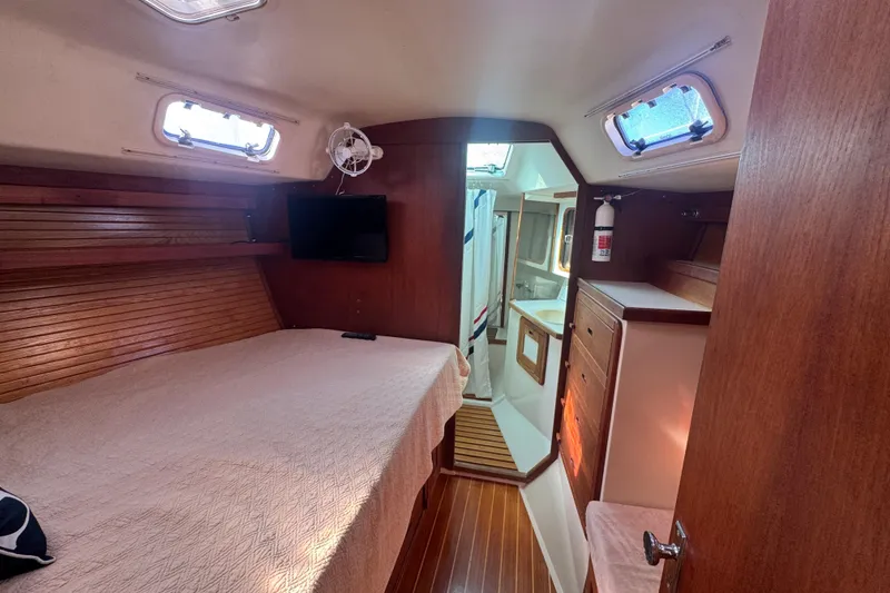 Interior of 1989 Catalina 42 sailboat cabin with bed, TV, and bathroom.