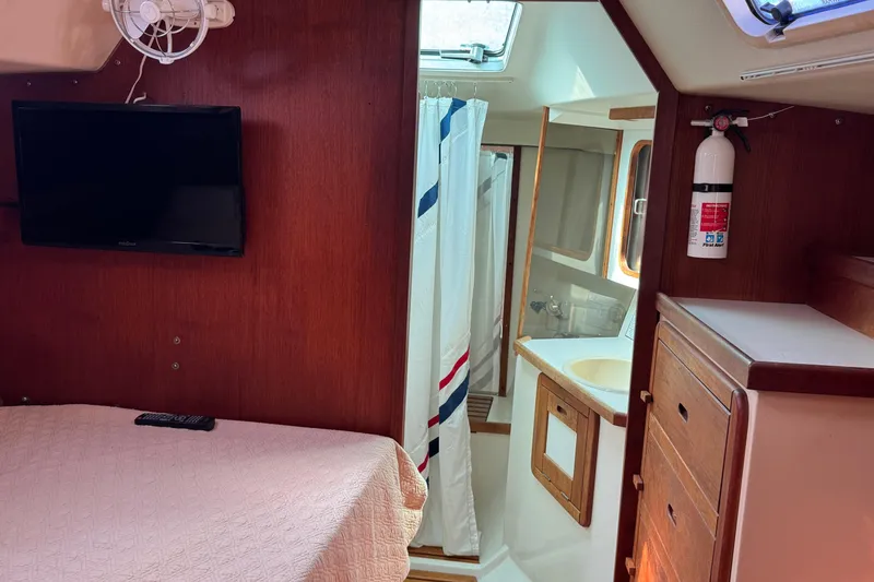 Interior of 1989 Catalina 42 yacht with bed, TV, and bathroom.