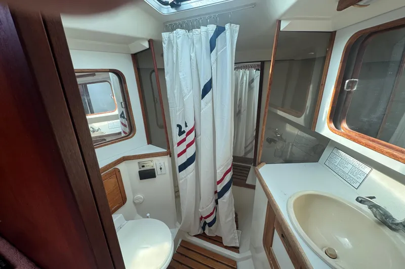 Bathroom interior of a 1989 Catalina 42 sailboat with shower and sink.
