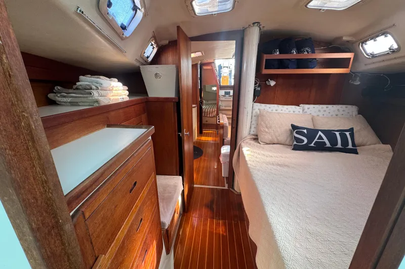 Cozy interior of 1989 Catalina 42 sailboat with wood finish and comfortable bedding.