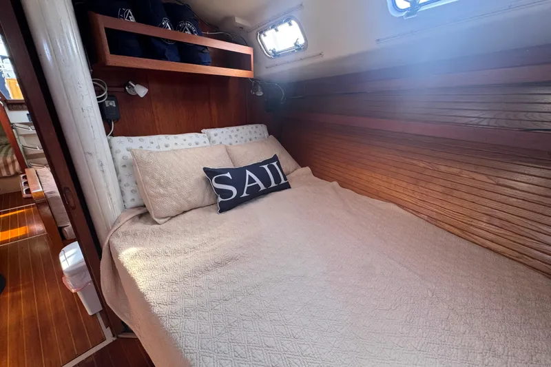 Cozy cabin interior of 1989 Catalina 42 sailboat with comfortable bedding and nautical decor.