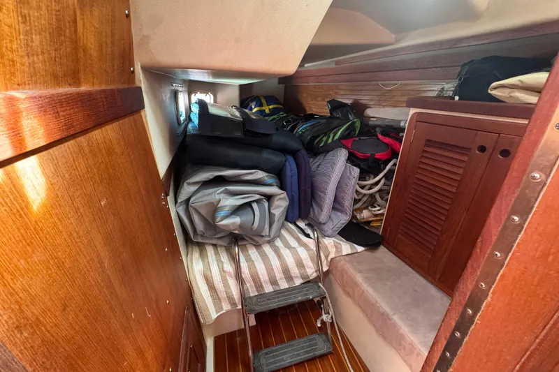 Cozy cabin interior of a 1989 Catalina 42 sailboat with storage and wooden finishes.
