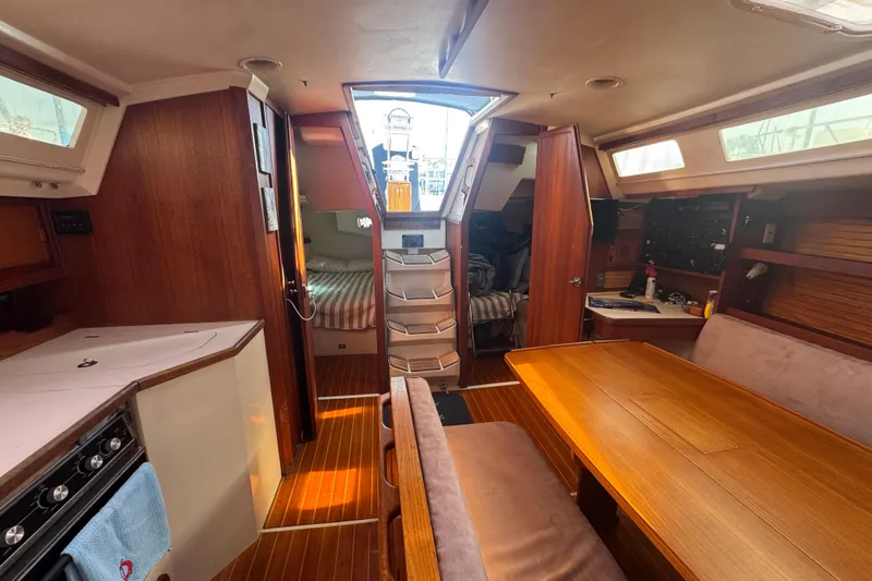 Interior of a 1989 Catalina 42 sailboat with wood finishes and cozy seating area.