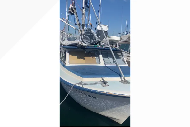 1977 Roberts 30 boat docked in marina, blue and white exterior.