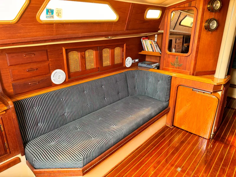 1978 Islander 36 yacht interior with striped seating, wooden cabinetry, and nautical decor.