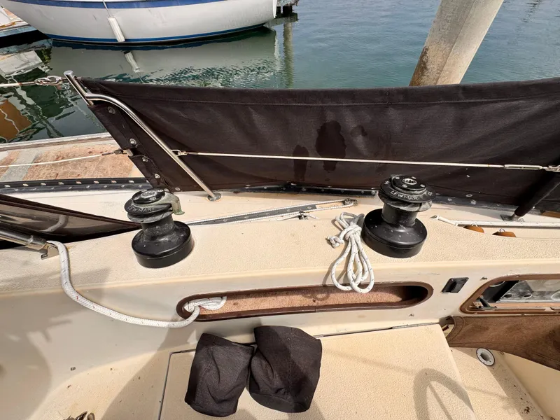 Cockpit of 1978 Islander 36 sailboat with winches and ropes, docked at marina.