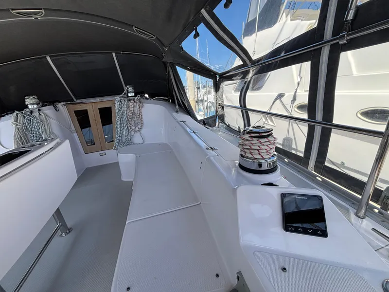 2019 Catalina 385 sailboat cockpit with winch, ropes, and seating under a canopy.