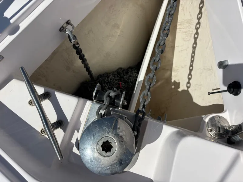 Anchor chain compartment on a 2019 Catalina 385 sailboat, featuring metal chains and winch.