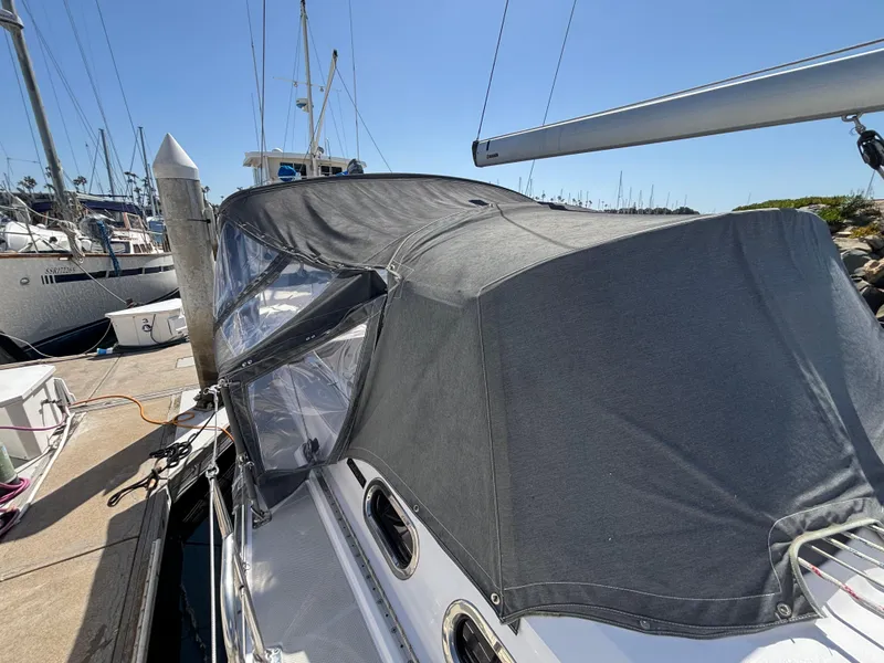 Sailboat Catalina 385 (2019) docked with protective cover, sunny marina setting.