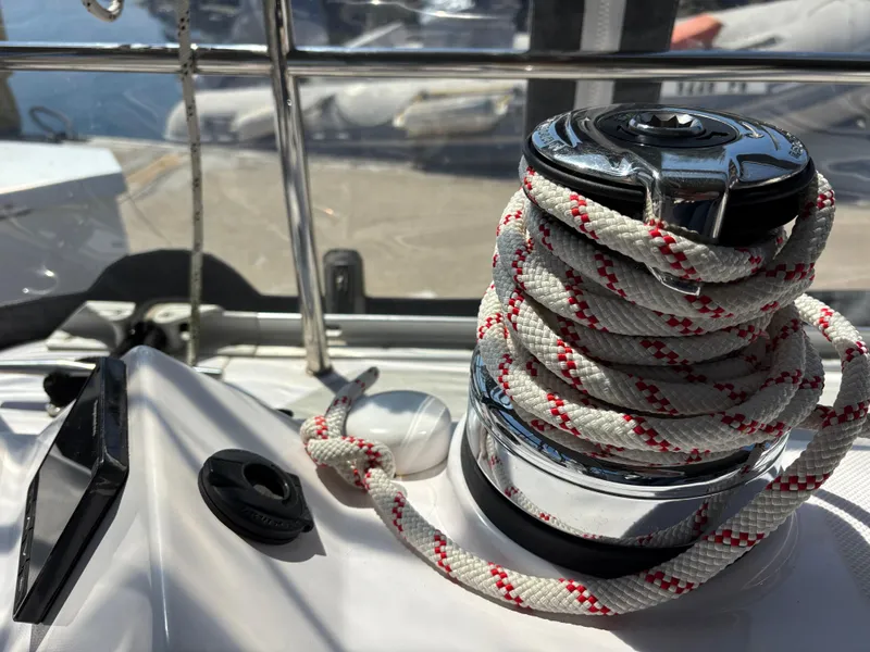 Winch with rope on 2019 Catalina 385 sailboat deck, docked in marina.