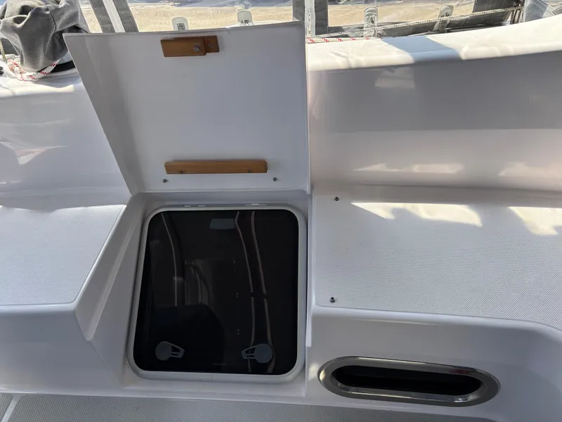 Open hatch on 2019 Catalina 385 sailboat deck, showing storage compartment.