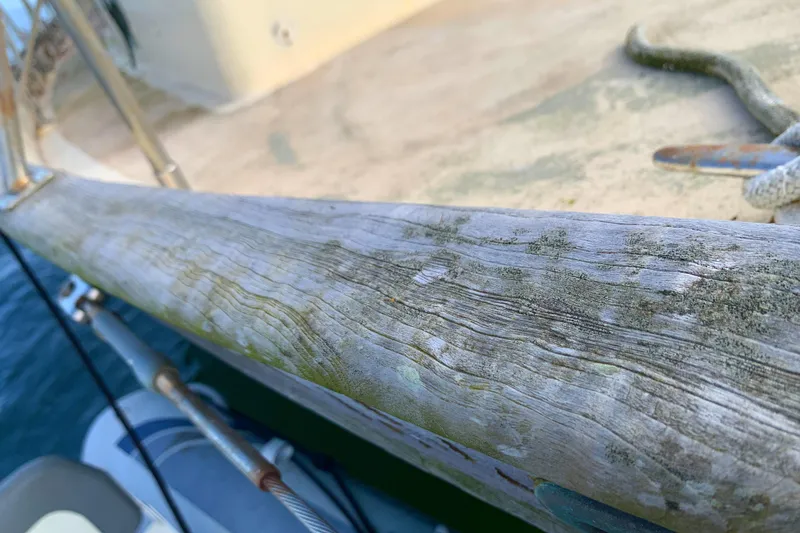 Weathered wooden railing on 1980 Tayana Pilot House sailboat deck.