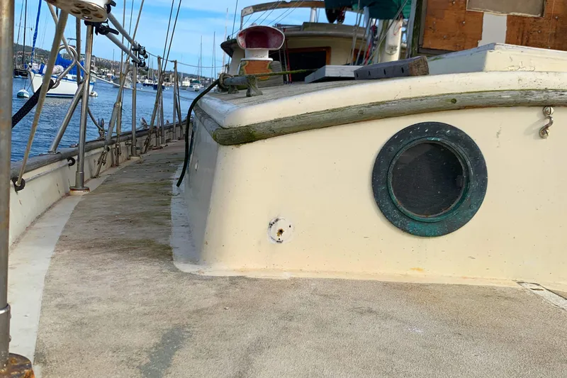 1980 Tayana Pilot House sailboat deck with porthole, docked at marina.