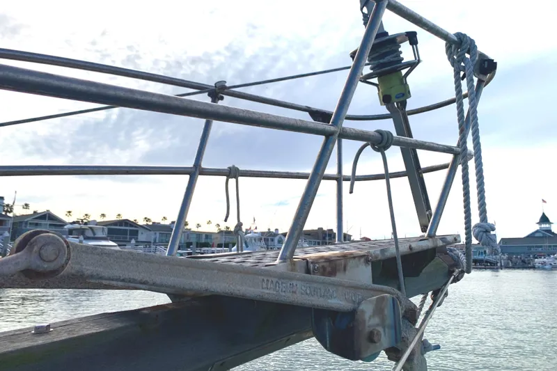 Bowsprit of 1980 Tayana Pilot House sailboat with marina background.