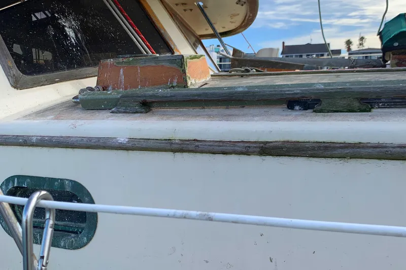1980 Tayana Pilot House sailboat deck with weathered wood and metal fittings.