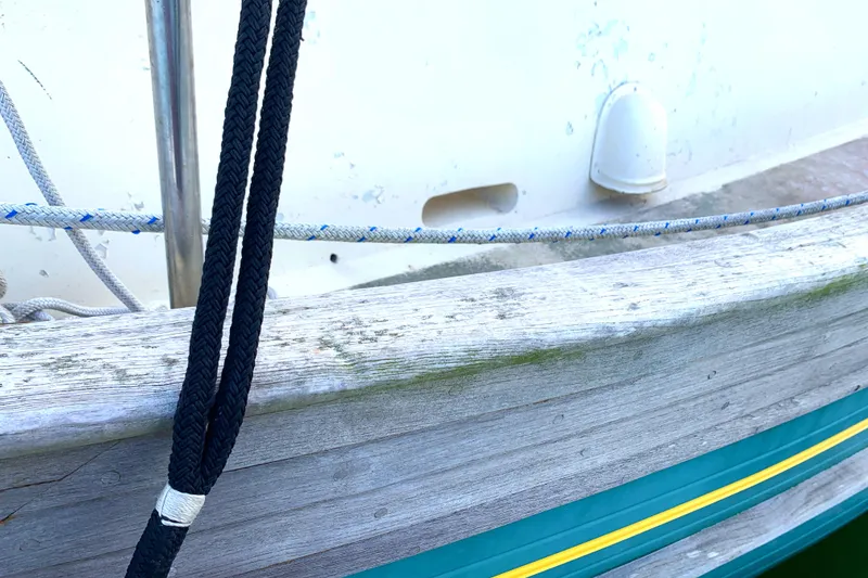Close-up of 1980 Tayana Pilot House boat deck with ropes and weathered wood.