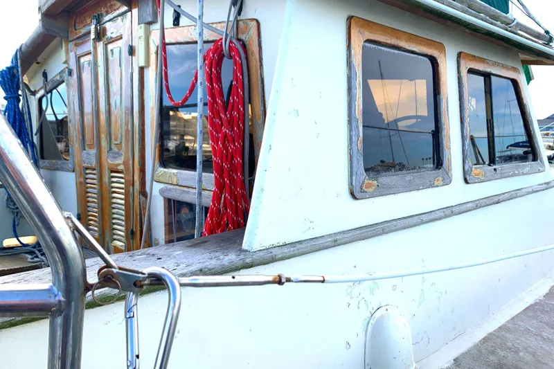 1980 Tayana Pilot House boat with wooden accents and colorful ropes.