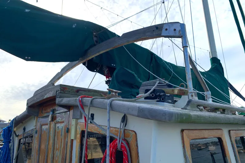 1980 Tayana Pilot House sailboat with green tarpaulin and wooden details.