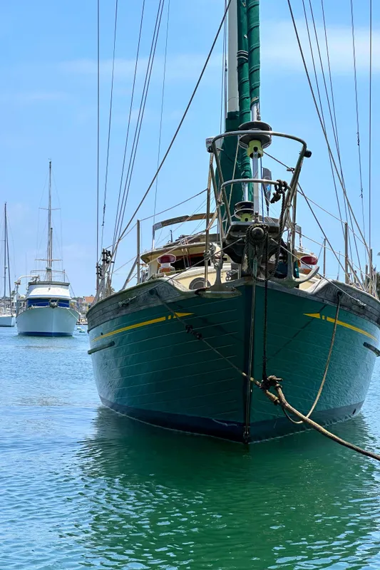 1980 Tayana Pilot House sailboat anchored in calm waters, with other boats in the background.