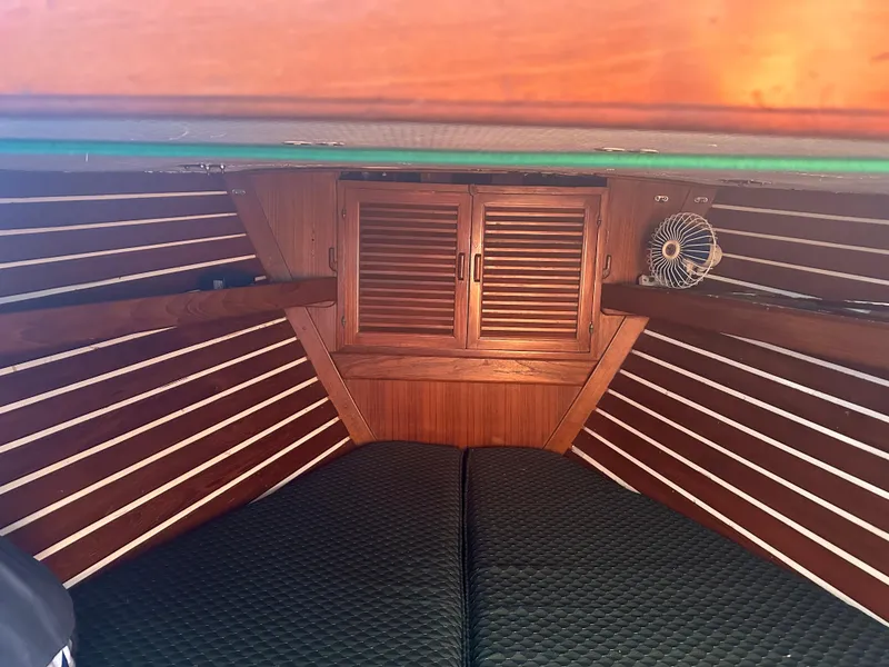 Interior of 1980 Tayana Pilot House with wooden paneling and cozy sleeping area.