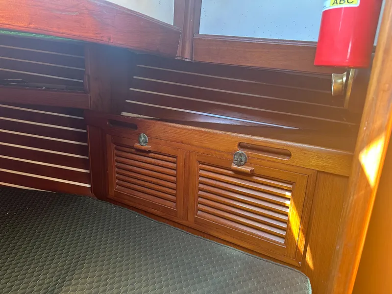 1980 Tayana Pilot House interior with wooden cabinetry and fire extinguisher.