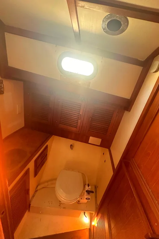 1980 Tayana Pilot House bathroom with wooden cabinetry and a compact toilet.