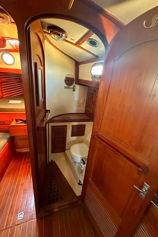 1980 Tayana Pilot House interior with wooden finish and compact bathroom.