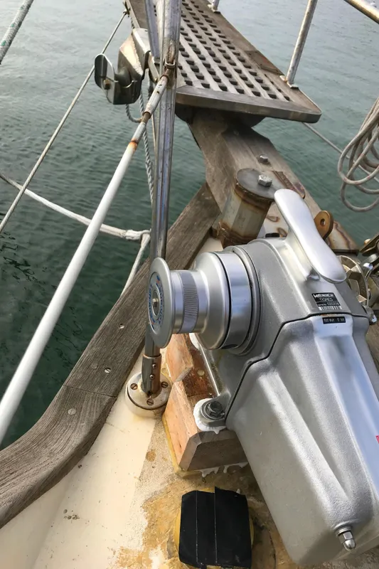 1980 Tayana Pilot House sailboat deck with winch and railing, overlooking calm water.