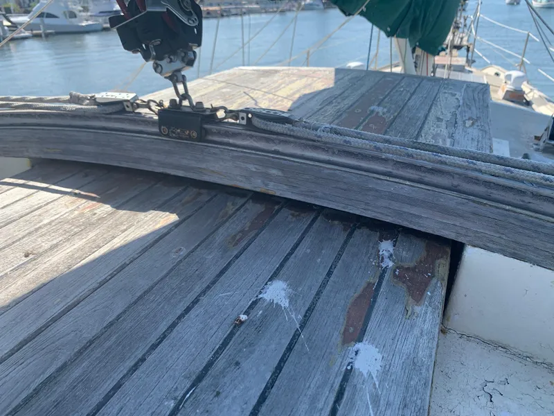 Weathered deck of 1980 Tayana Pilot House sailboat with visible wear and hardware.