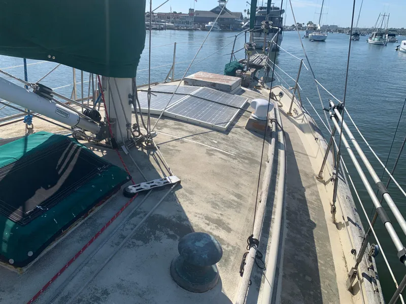 1980 Tayana Pilot House sailboat deck with solar panels, docked in a marina.