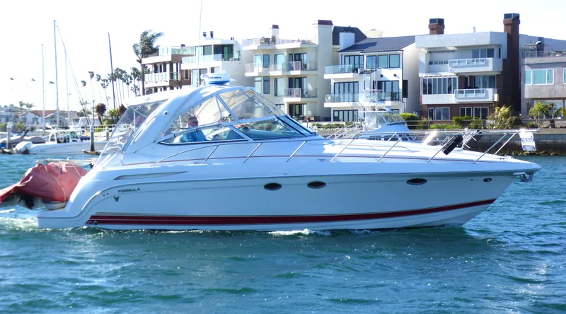 2003 Formula 37 PC yacht cruising near waterfront homes.