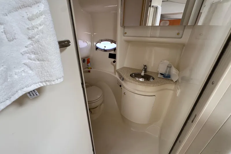 2003 Formula 37 Performance Cruiser bathroom with sink, toilet, and porthole window.