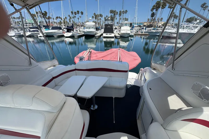 2003 Formula 37 Performance Cruiser interior with marina view, featuring white seating and table.