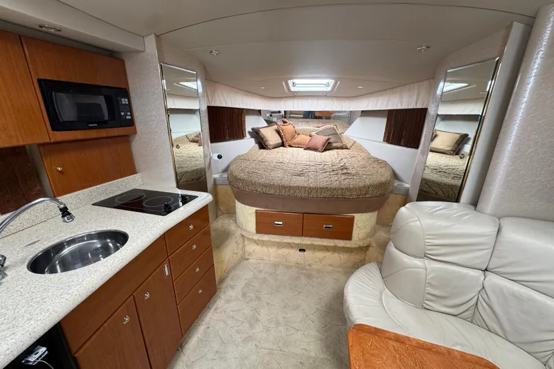 Luxurious interior of a 2003 Formula 37 Performance Cruiser with kitchen and cozy bed.
