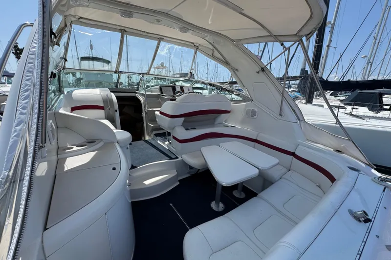 2003 Formula 37 Performance Cruiser interior with white seating and table, docked at marina.