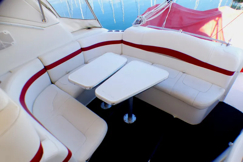 2003 Formula 37 PC boat interior with white and red seating and dual tables.