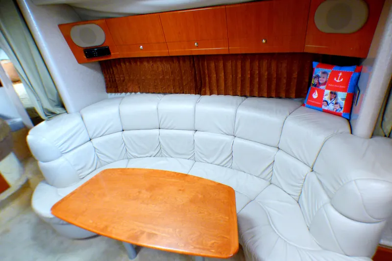 2003 Formula 37 PC yacht interior with curved leather seating and wooden table.