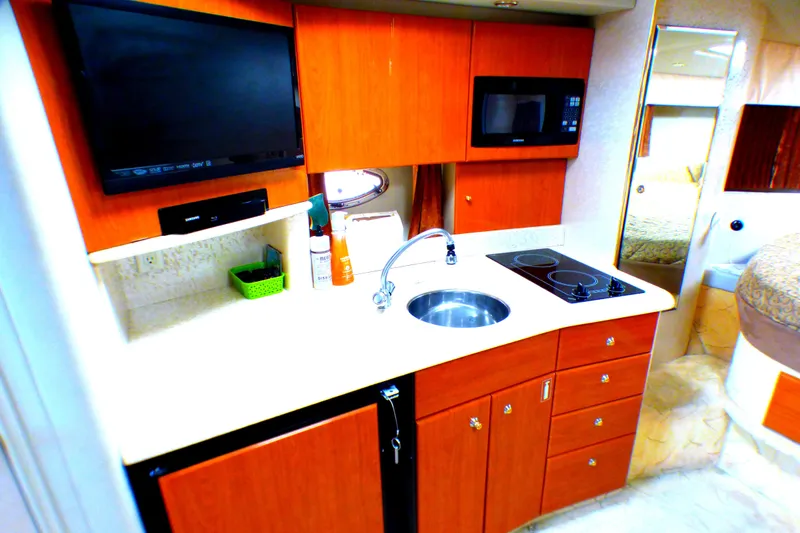 2003 Formula 37 PC yacht kitchen with sink, stove, microwave, and TV.