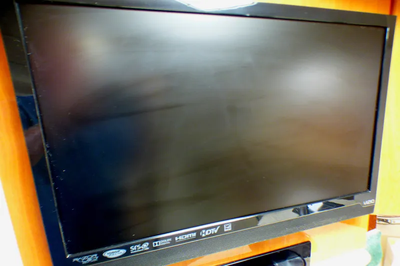 Flat-screen TV mounted on a wooden wall inside a 2003 Formula 37 PC boat.