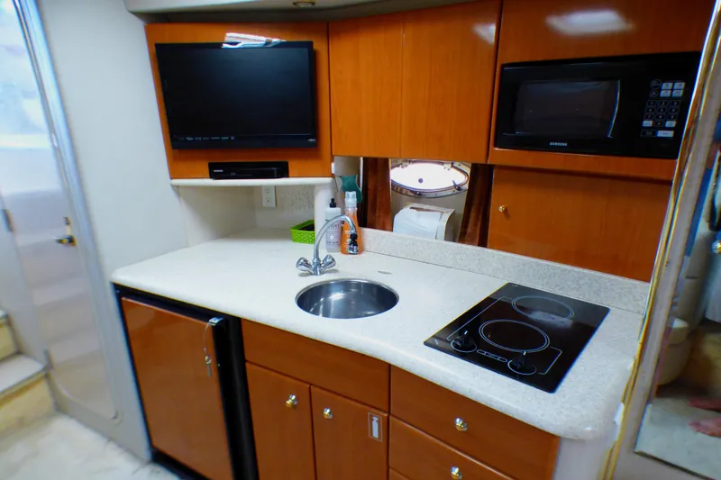 2003 Formula 37 PC yacht kitchen with sink, stove, microwave, and TV.