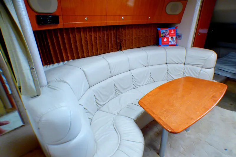 Luxurious interior of 2003 Formula 37 PC yacht with curved leather seating and wooden table.