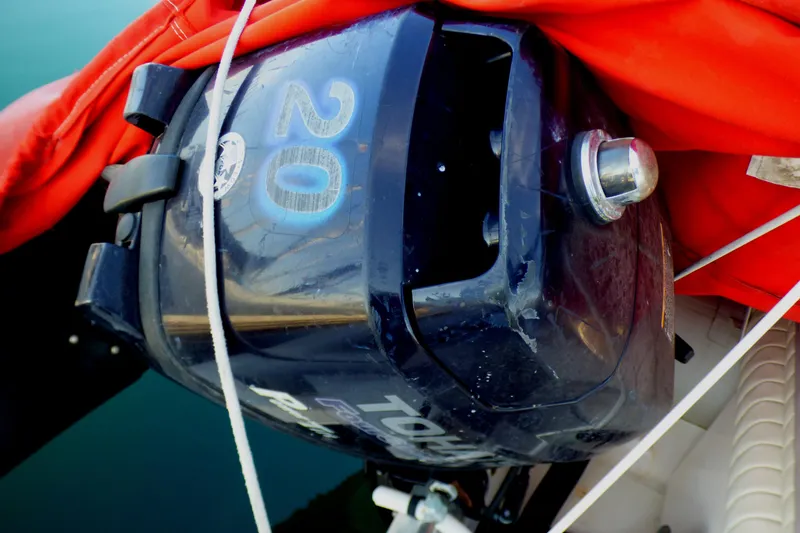 Outboard motor on a 2003 Formula 37 PC boat, covered with an orange tarp.