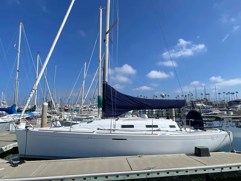 2004 Beneteau 36.7 sailboat docked at marina under blue sky.