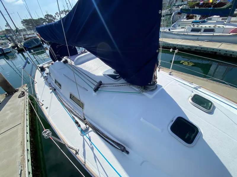 2004 Beneteau 36.7 sailboat docked at marina, blue sail cover, white deck.