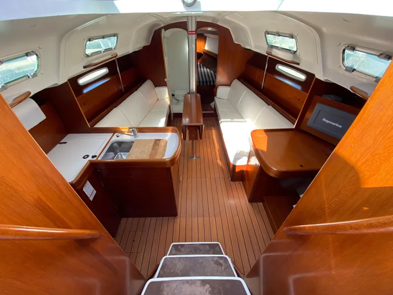 Interior of 2004 Beneteau 36.7 sailboat with wood finish and white seating.