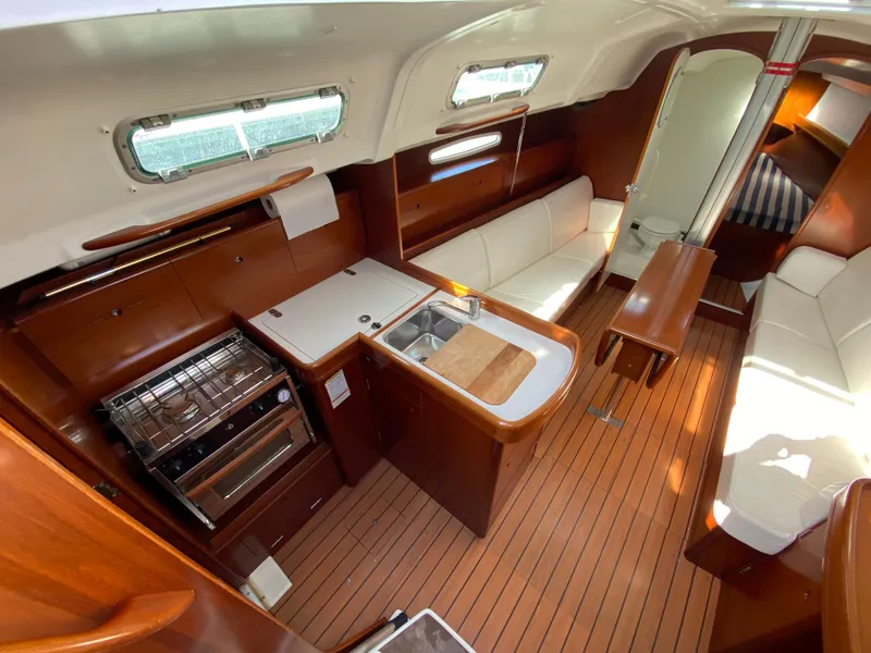 Interior of 2004 Beneteau 36.7 sailboat with kitchen, seating, and wooden flooring.