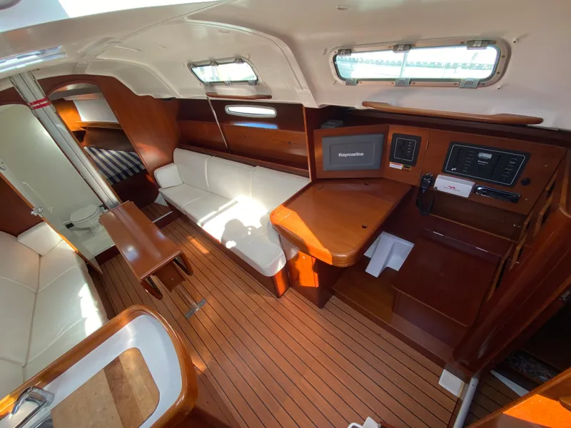 Interior of a 2004 Beneteau 36.7 sailboat with wood finish and white seating.